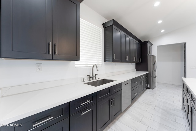 kitchen with appliances with stainless steel finishes, sink, and vaulted ceiling