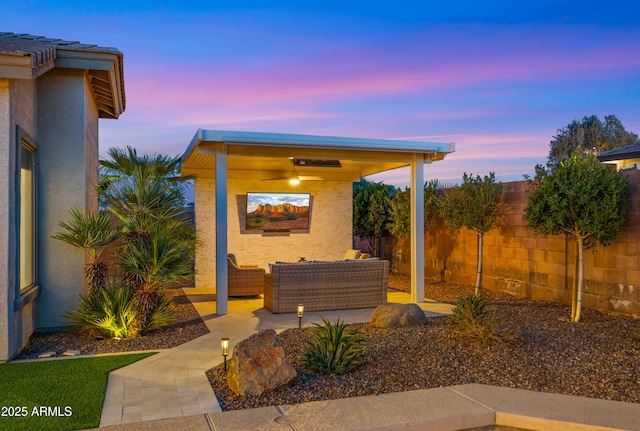 patio terrace at dusk featuring fence