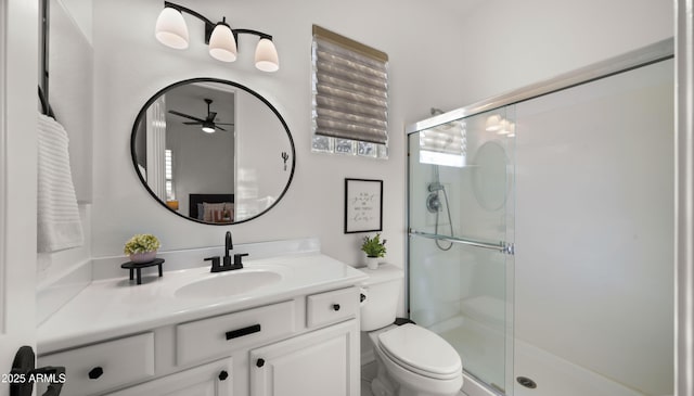 bathroom with vanity, a shower stall, toilet, and ceiling fan