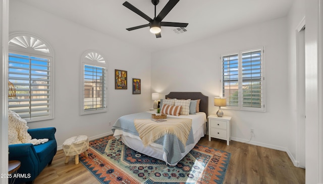 bedroom featuring visible vents, baseboards, and wood finished floors