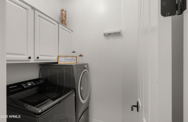 clothes washing area with baseboards, cabinet space, and separate washer and dryer