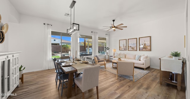 dining space with visible vents, a ceiling fan, baseboards, and wood finished floors