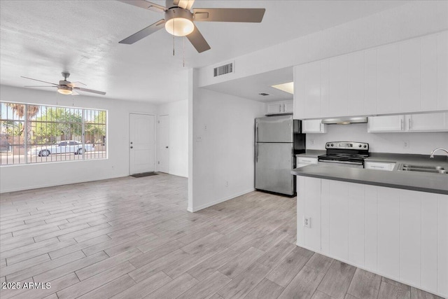 kitchen with visible vents, a sink, dark countertops, a ceiling fan, and appliances with stainless steel finishes