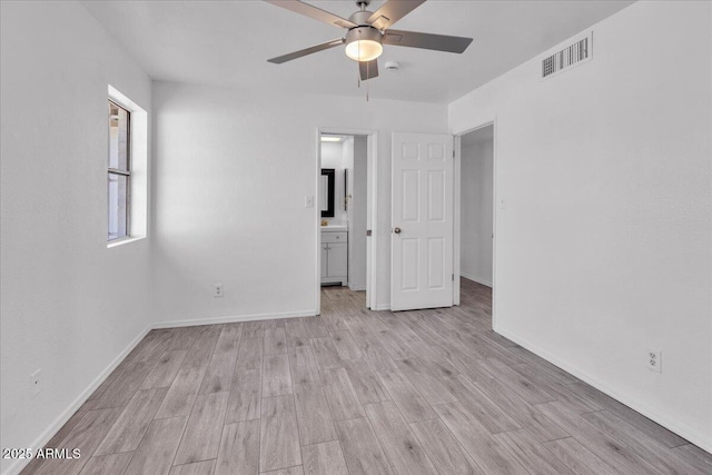 unfurnished bedroom featuring baseboards, visible vents, ensuite bathroom, and light wood-style floors