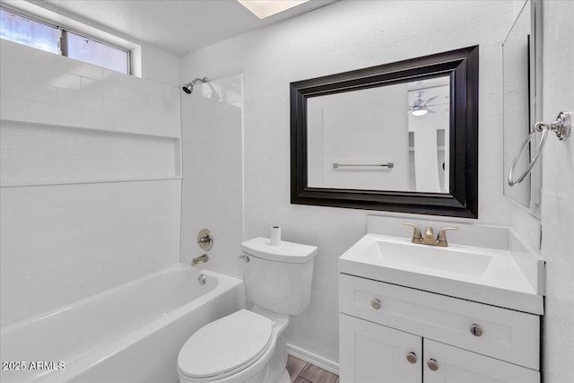 bathroom featuring vanity, tub / shower combination, and toilet