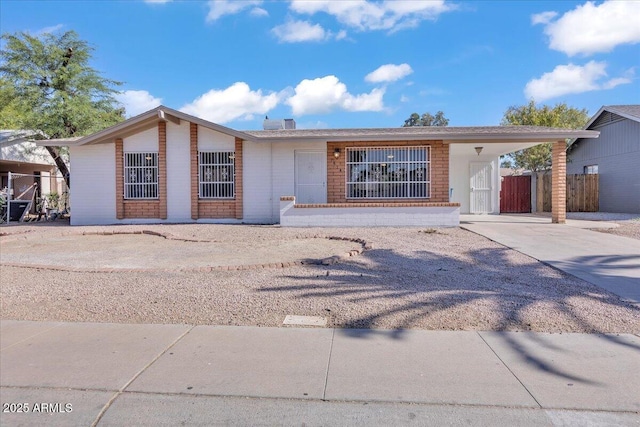 single story home with a carport, fence, and concrete driveway