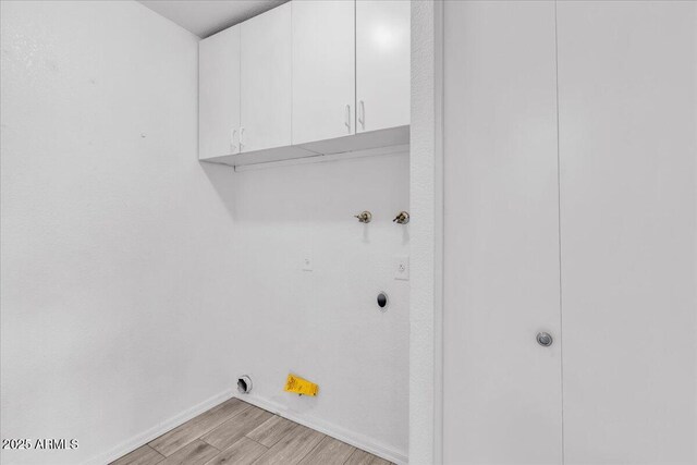 laundry area featuring baseboards, light wood-style flooring, cabinet space, and electric dryer hookup