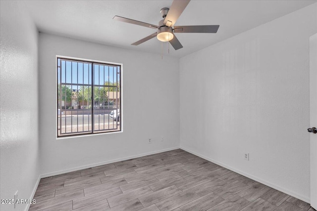 empty room with baseboards, a ceiling fan, and wood finished floors