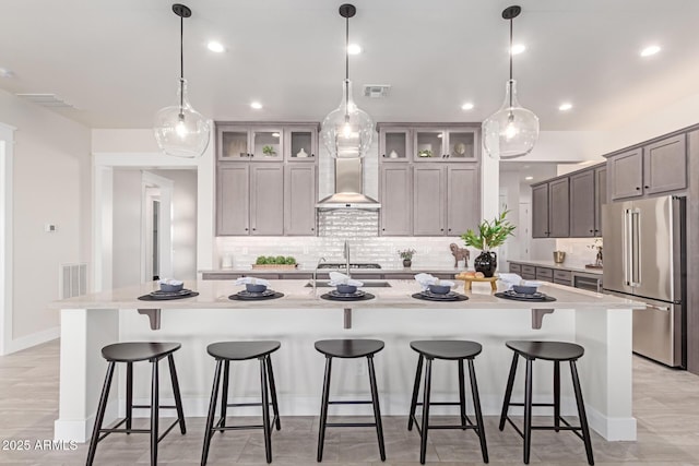 3940 Rolling Stock Way, Wickenburg, AZ 85390 - kitchen featuring a kitchen bar, tasteful backsplash, wall chimney range hood, visible vents, and stainless steel appliances