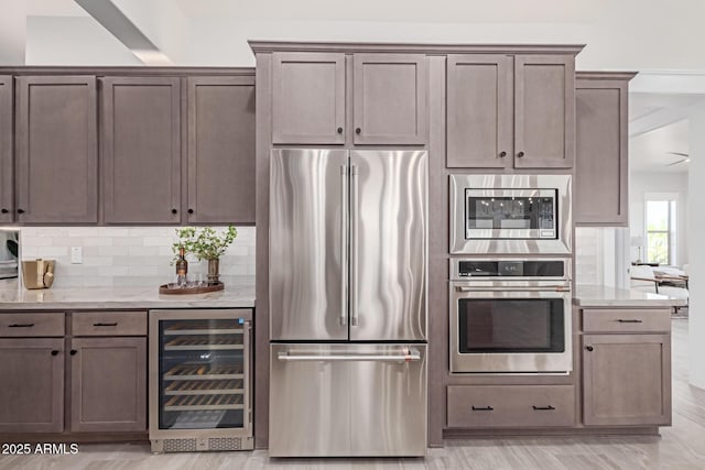3940 Rolling Stock Way, Wickenburg, AZ 85390 - kitchen with decorative backsplash, light stone countertops, beverage cooler, and stainless steel appliances
