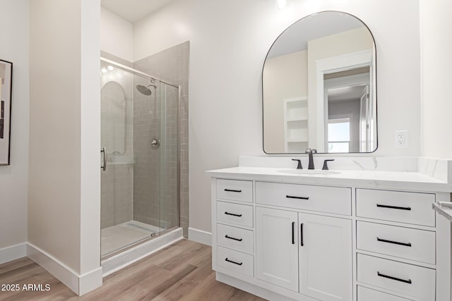3940 Rolling Stock Way, Wickenburg, AZ 85390 - bathroom featuring baseboards, a stall shower, wood finished floors, and vanity