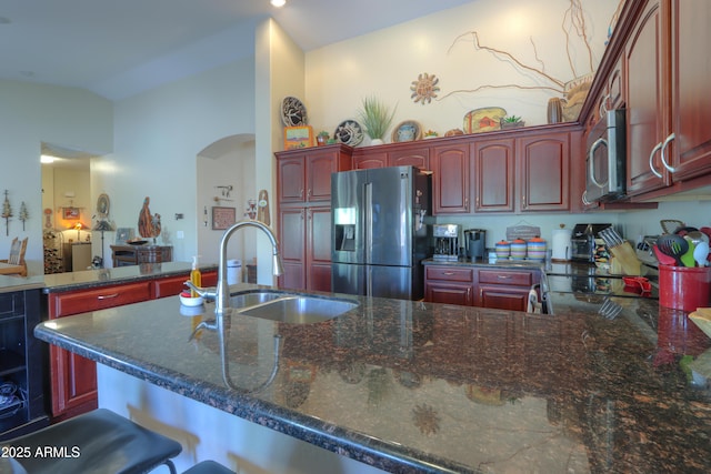 kitchen with lofted ceiling, stainless steel appliances, a breakfast bar, and sink