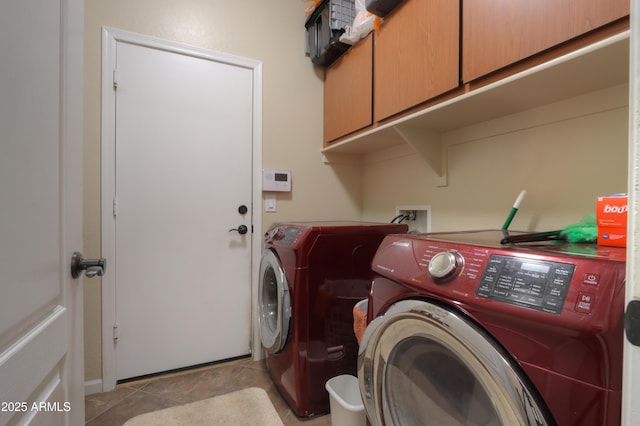 laundry room featuring cabinets, separate washer and dryer, and light tile patterned floors