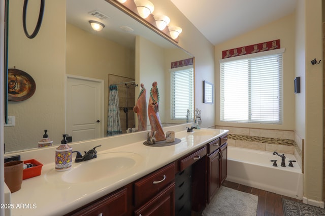 bathroom featuring vanity, hardwood / wood-style floors, vaulted ceiling, and separate shower and tub