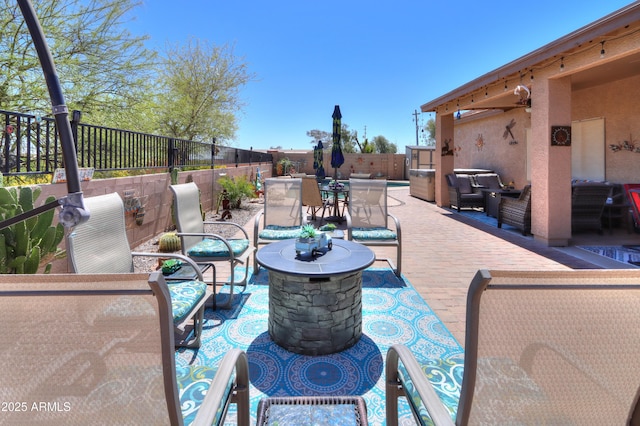 view of patio with an outdoor living space with a fire pit