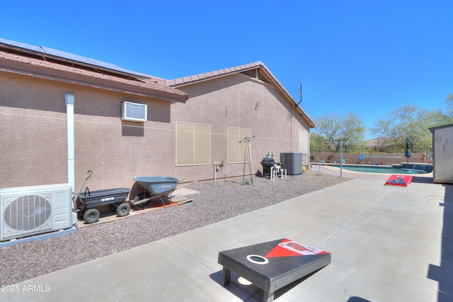 view of patio featuring central AC, a fenced in pool, and ac unit