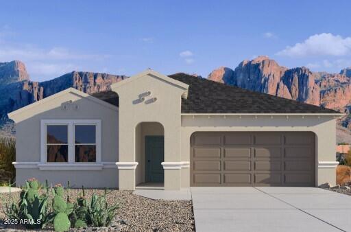 view of front of property featuring a mountain view, a garage, driveway, and stucco siding