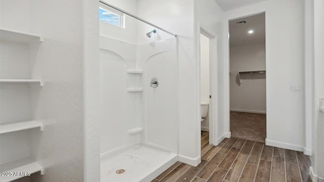 full bathroom featuring wood finish floors, visible vents, a spacious closet, and a shower stall