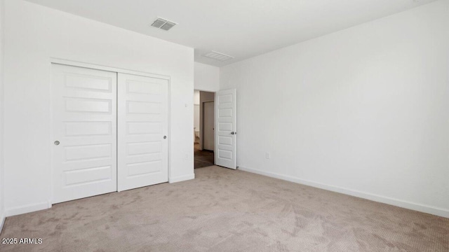 unfurnished bedroom featuring baseboards, visible vents, carpet floors, and a closet