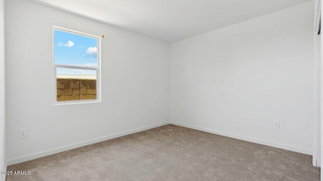 empty room featuring carpet flooring and baseboards