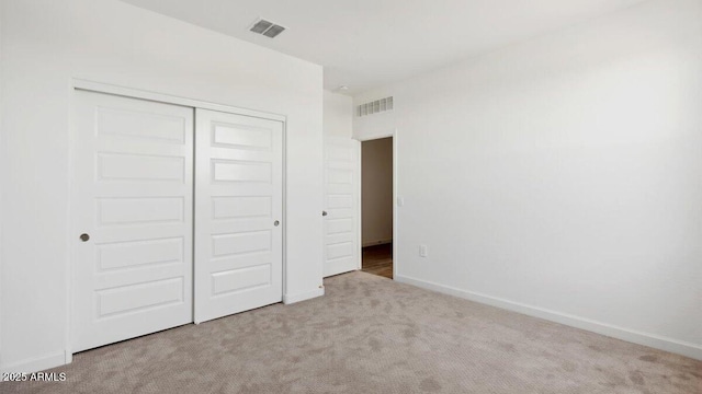 unfurnished bedroom featuring baseboards, visible vents, carpet floors, and a closet