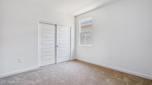 unfurnished bedroom featuring a closet, carpet flooring, and baseboards