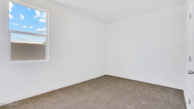 carpeted spare room featuring baseboards