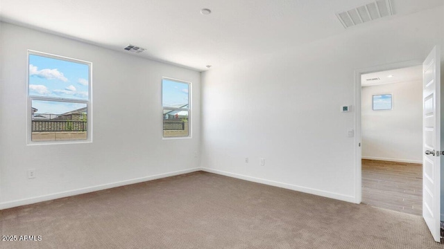 carpeted empty room with baseboards and visible vents