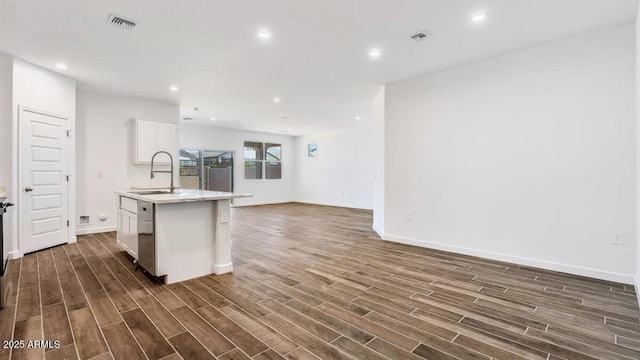 kitchen with visible vents, dark wood-type flooring, open floor plan, a center island with sink, and a sink