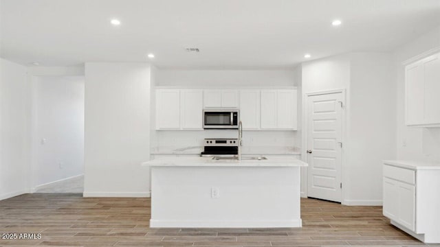 kitchen featuring visible vents, stainless steel microwave, light countertops, stove, and wood tiled floor