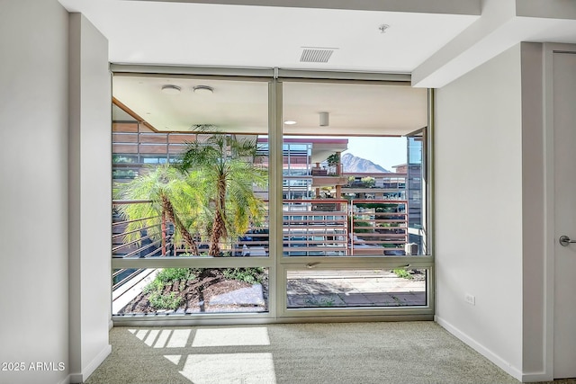 entryway featuring visible vents, baseboards, and carpet