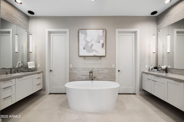 bathroom with tile patterned flooring, vanity, and a tub