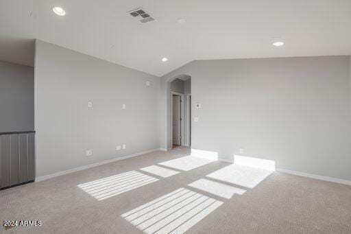 empty room with vaulted ceiling and carpet floors