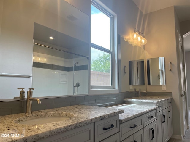 bathroom with a shower and double sink vanity