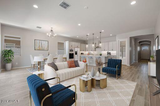 living room featuring light hardwood / wood-style floors and an inviting chandelier