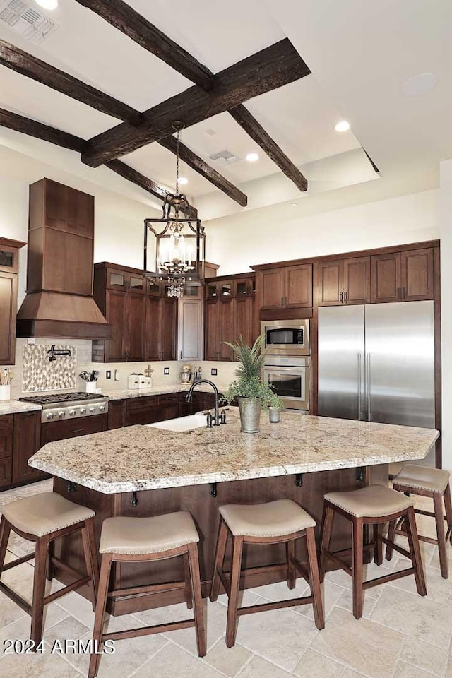 kitchen with premium range hood, appliances with stainless steel finishes, a large island, and a breakfast bar