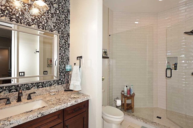 bathroom featuring vanity, a shower with shower door, and toilet