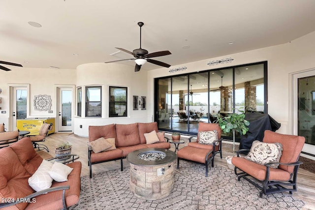 living room with ceiling fan, light wood-type flooring, and plenty of natural light