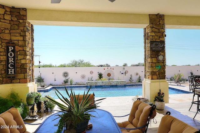 view of swimming pool with pool water feature and a patio area