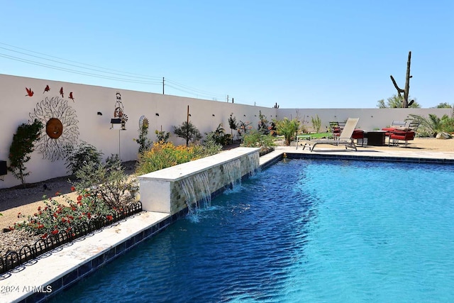 view of swimming pool with pool water feature and a patio area