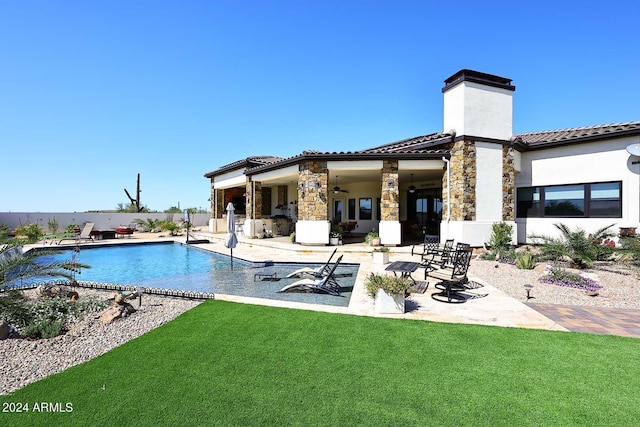 back of property featuring a fenced in pool, a lawn, and a patio