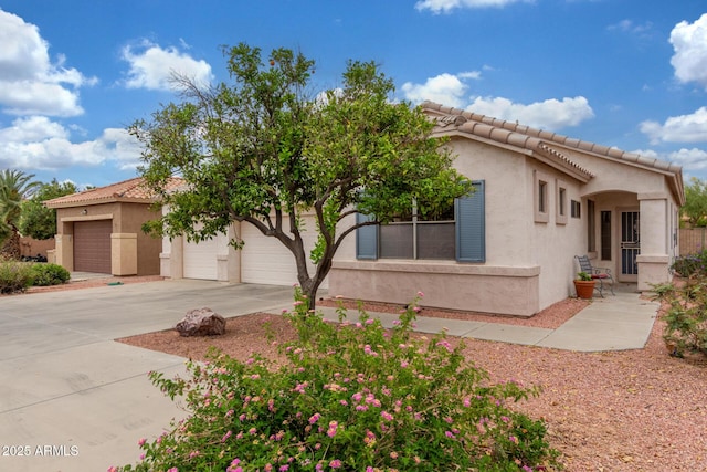 view of front of house with a tile roof, concrete driveway, and stucco siding