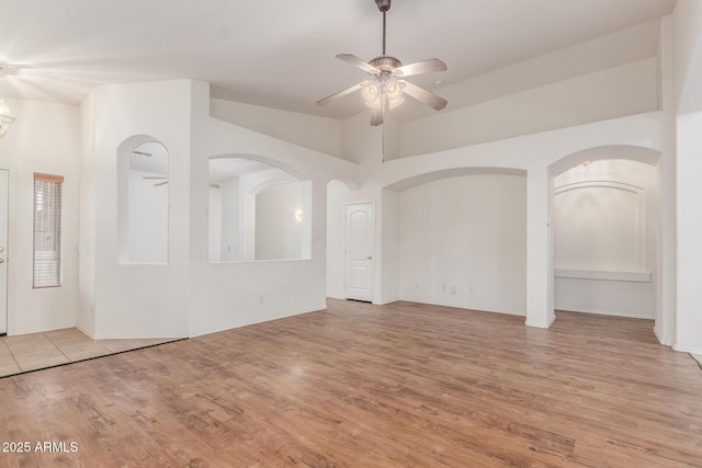 interior space featuring a ceiling fan, wood finished floors, and high vaulted ceiling
