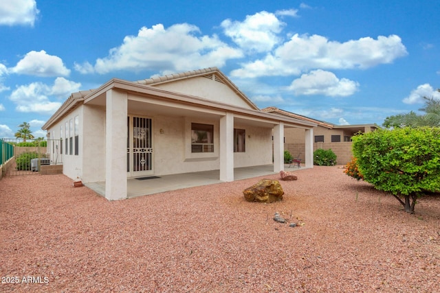 view of front of home with a patio, a fenced backyard, cooling unit, and stucco siding
