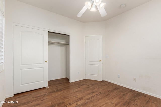 unfurnished bedroom featuring ceiling fan, baseboards, wood finished floors, and a closet