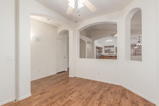 empty room featuring wood finished floors, baseboards, and ceiling fan