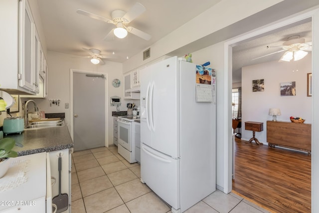 kitchen with visible vents, a ceiling fan, white appliances, and a sink