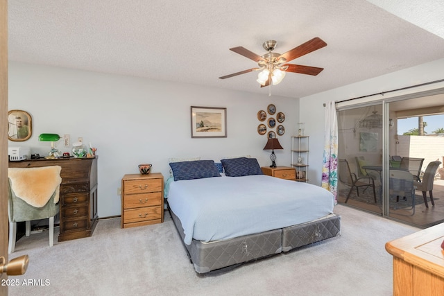 carpeted bedroom featuring a textured ceiling, access to exterior, and a ceiling fan