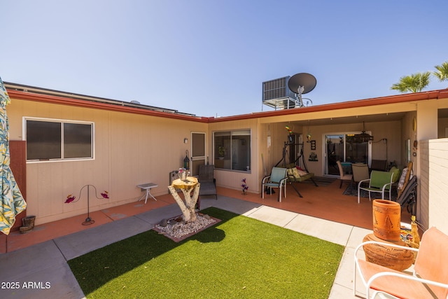 back of property featuring a lawn, central AC unit, and a patio