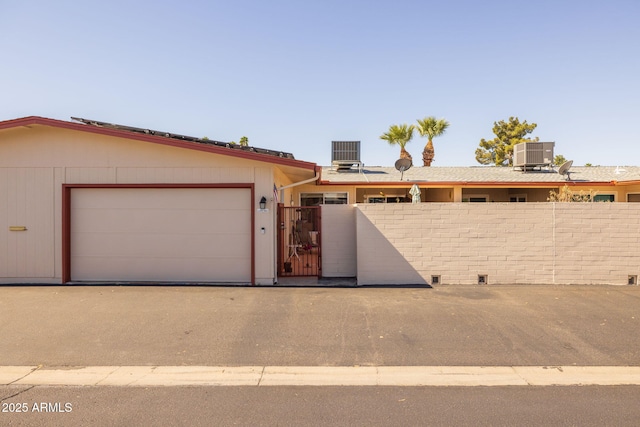 exterior space with a gate, central air condition unit, and fence